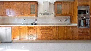 A kitchen with wooden cabinets, a stainless steel sink, and a built-in oven.