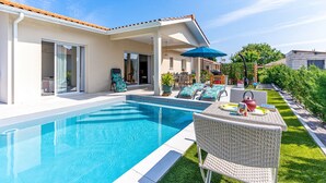 A swimming pool with a covered patio area, outdoor furniture, and a well-maintained lawn. - Beautiful Villa 500 m from the Lake with Pool and Air Conditioning (Gastes)