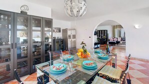 A dining area with a glass table, chairs, and a decorative globe light. - Vacation Home "Paraíso" with Sea View, Pool & Wi-Fi (Puerto de la cruz)