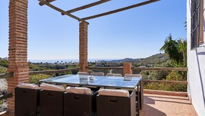 A terrace with a glass table and wicker chairs, overlooking a scenic landscape. - Country House 'La Solana' with Sea View, Private Pool and Wi-Fi (Frigiliana)