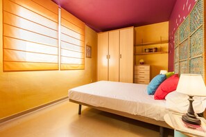 A bedroom with a bed, a dresser, a nightstand, and a wall with a decorative panel. - Holiday Home 'La Cantonada' with Private Terrace (Sant Pere de Ribes)