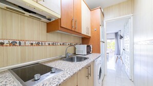 A kitchen with a built-in microwave, stainless steel sink, and granite countertop. - Studio 'Gaviotas 4' with Communal Pool, Wi-Fi, and Air Conditioning (Aguadulce)