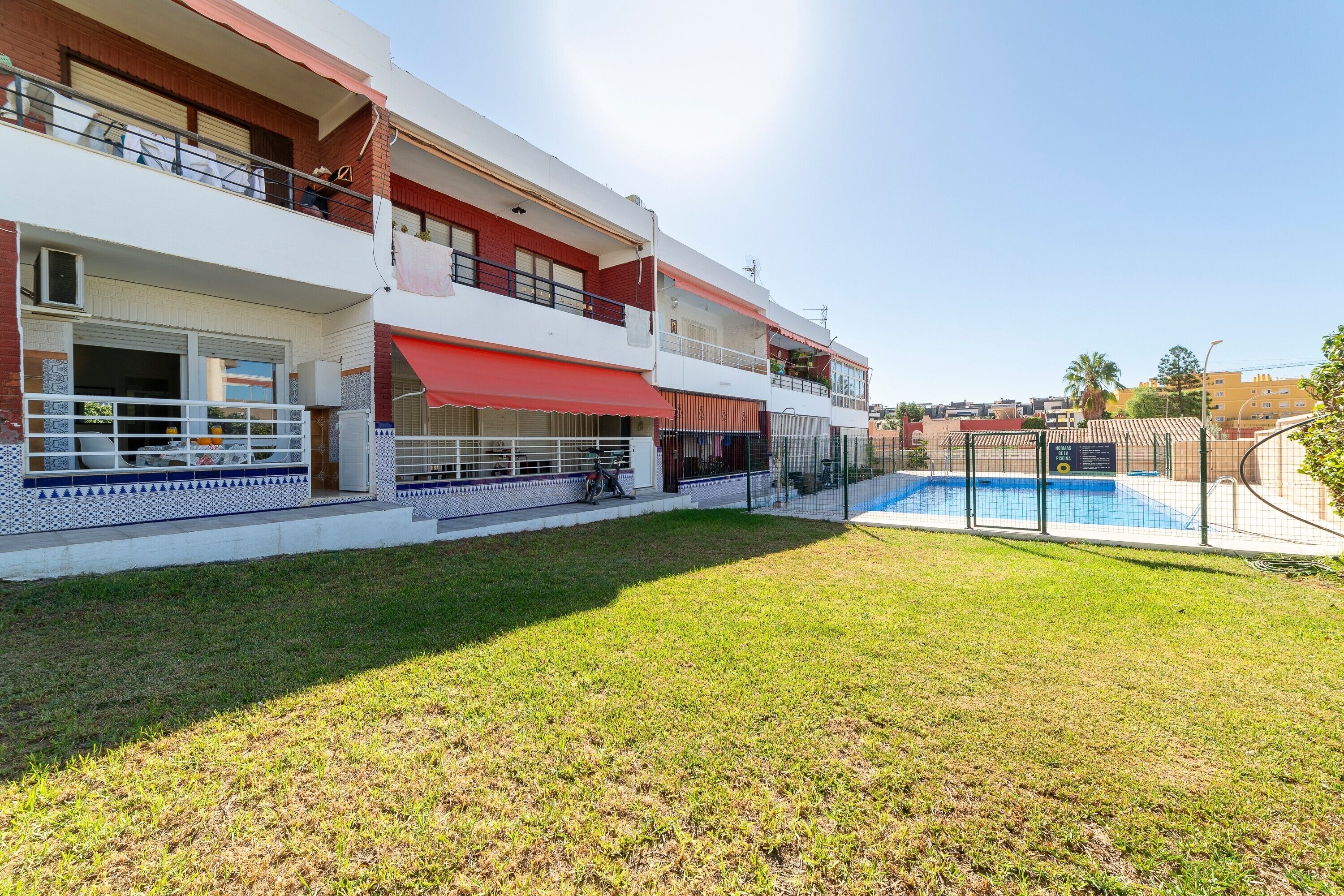 Un edificio residencial de varios pisos con piscina, balcones y un patio cubierto.