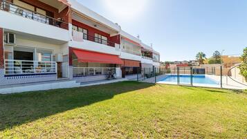 Un edificio residencial de varios pisos con piscina, balcones y un patio cubierto.