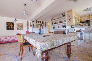Un coin repas avec une nappe à motifs, des chaises en bois et une table à manger.