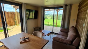 Una sala acogedora con un sofá, una mesa y un televisor instalado en la pared.