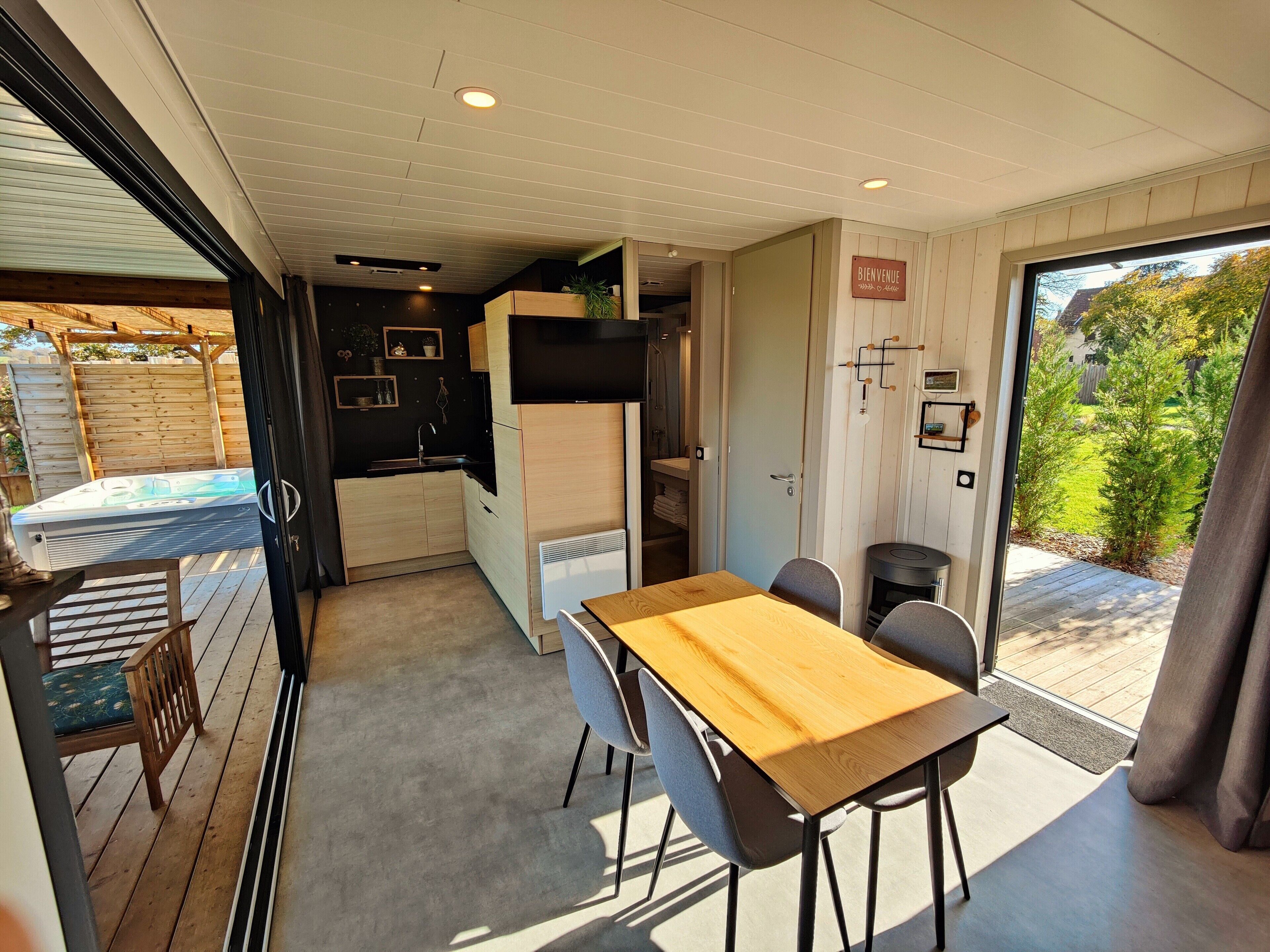 A compact kitchen with a dining area, a hot tub, and a view of the backyard.