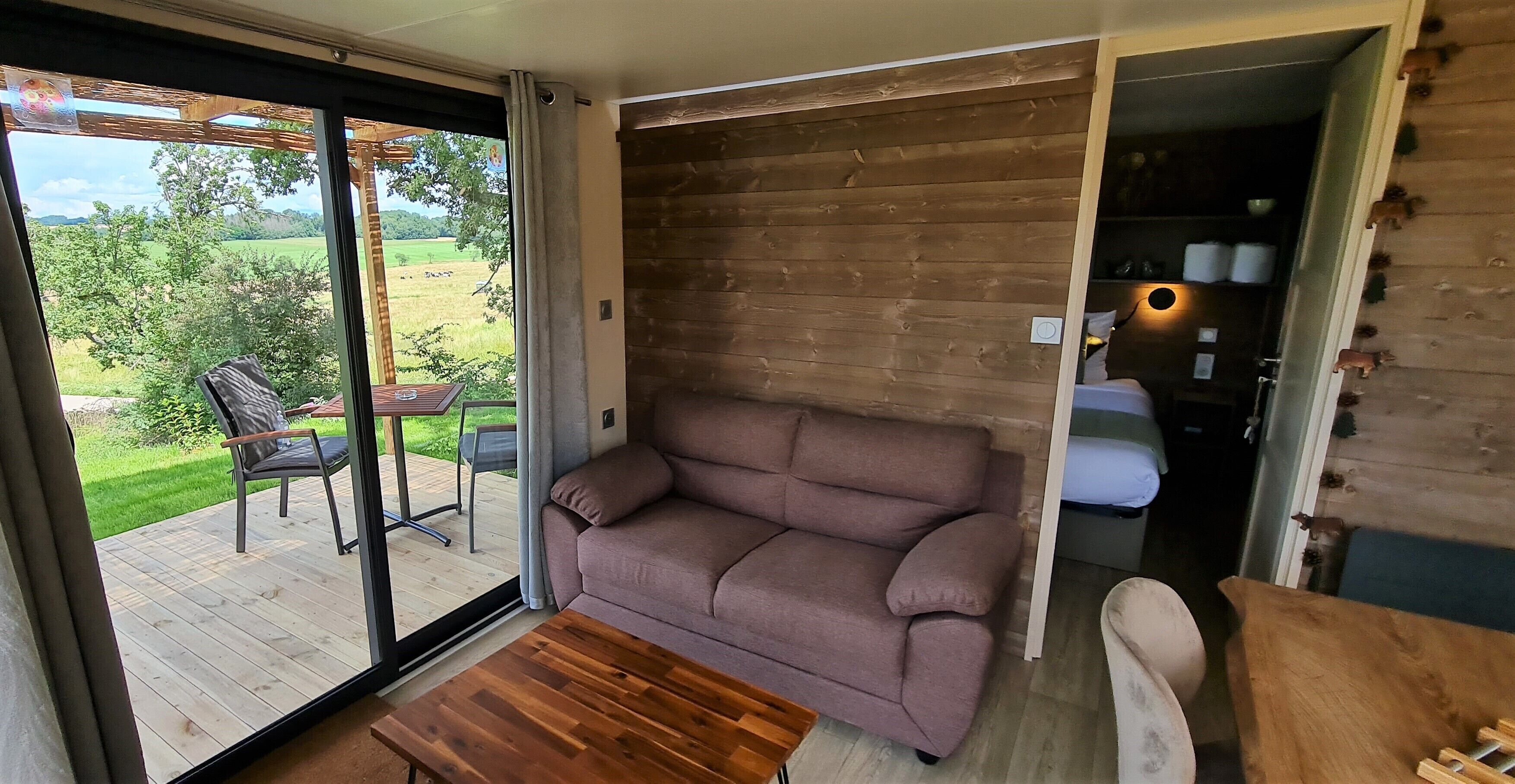 A modern interior with a wooden wall, a sofa, and a table.