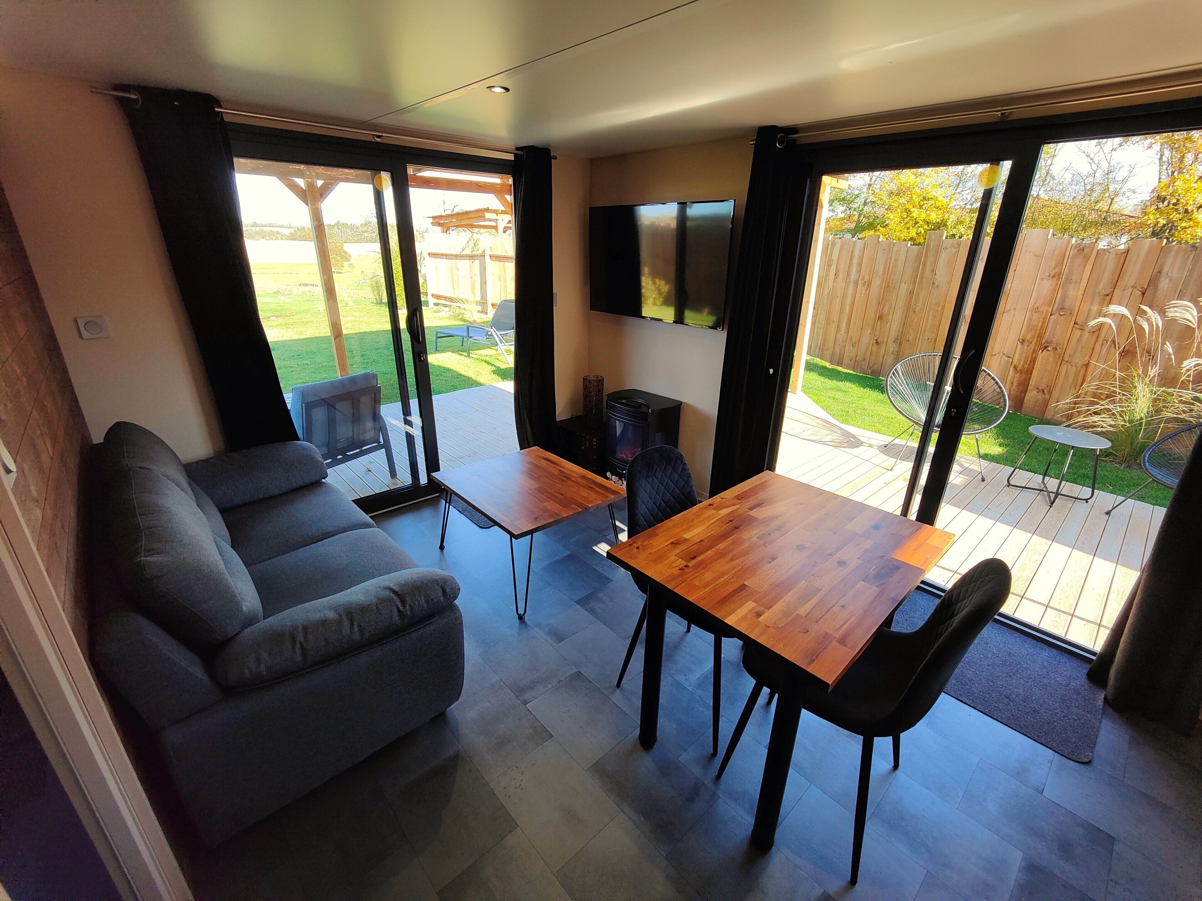 Un salon moderne avec un canapé, une table en bois et un téléviseur.