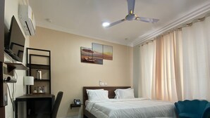 A hotel room with a bed, desk, chair, and a ceiling fan. - Post Ridge Hotel and Restaurant (Kweiman)