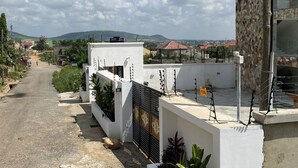 A residential street with modern houses, a paved road, and a clear sky. - Post Ridge Hotel and Restaurant (Kweiman)