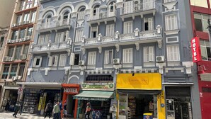 A multi-story hotel with balconies, a storefront with a yellow awning, and a visible 'Hotel' sign. - Hotel Quintino (São Paulo)