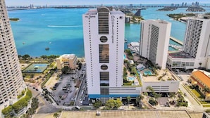 A high-rise hotel with a central atrium, surrounded by a marina and water views. - Bay View High-Rise | Private Balcony | StayCozy (Miami)