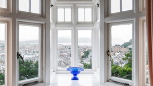Ein Zimmer mit großen Fenstern und Blick auf die Stadt.