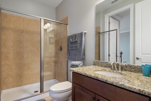 A bathroom with a shower, toilet, sink, and vanity. - Reunion Resort- Pool, Spa, Game Room, Disney, Golf Course, No resort Fees (Reunion)