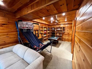 A wooden cabin interior with a hammock, a pool table, and shelves with various items. - Custom log home on 16 private acres, with Hot tub (Laurelville)
