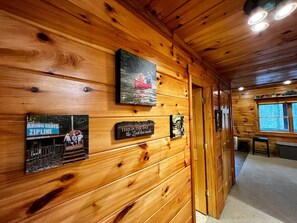 A wooden interior with a wooden wall, a framed picture, and a plaque.