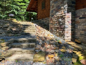 A stone staircase leading to a wooden building with a stone wall. - Custom log home on 16 private acres, with Hot tub (Laurelville)