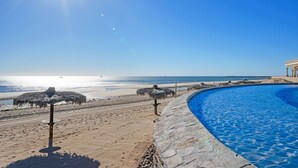 Una piscina con vista sulla spiaggia e sull'oceano.