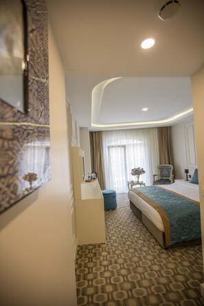 A modern hotel room with a large bed, a desk, and a chair. - Palde Hotel Spa (Istanbul)