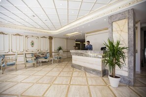 A reception area with a marble floor, ornate wall decorations, and a reception desk. - Palde Hotel Spa (Istanbul)