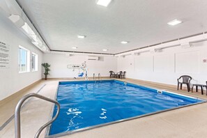 An indoor swimming pool with clear water, a metal ladder, and a ceiling with recessed lighting. - Quality Inn & Suites Ferdinand (Ferdinand)
