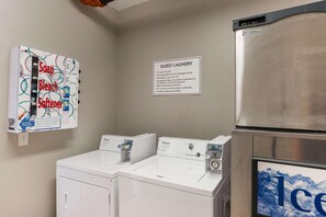 A laundry area with a sign indicating guest laundry use, a Prodigy refrigerator, and a Whirlpool washer. - Quality Inn & Suites Ferdinand (Ferdinand)