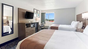 A hotel room with two beds, a desk with a chair, a TV mounted on the wall, and a large window with a view of the outdoors. - Quality Inn & Suites Ferdinand (Ferdinand)