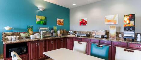 A kitchen with a dining area, equipped with a microwave, toaster, and coffee maker.