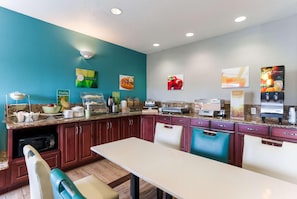 A kitchen with a dining area, equipped with a microwave, toaster, and coffee maker. - Quality Inn & Suites Ferdinand (Ferdinand)