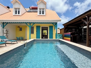 Ein Schwimmbad mit einem Haus im Hintergrund.