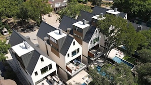 A modern residential complex with multiple houses, a shared swimming pool, and a landscaped garden.