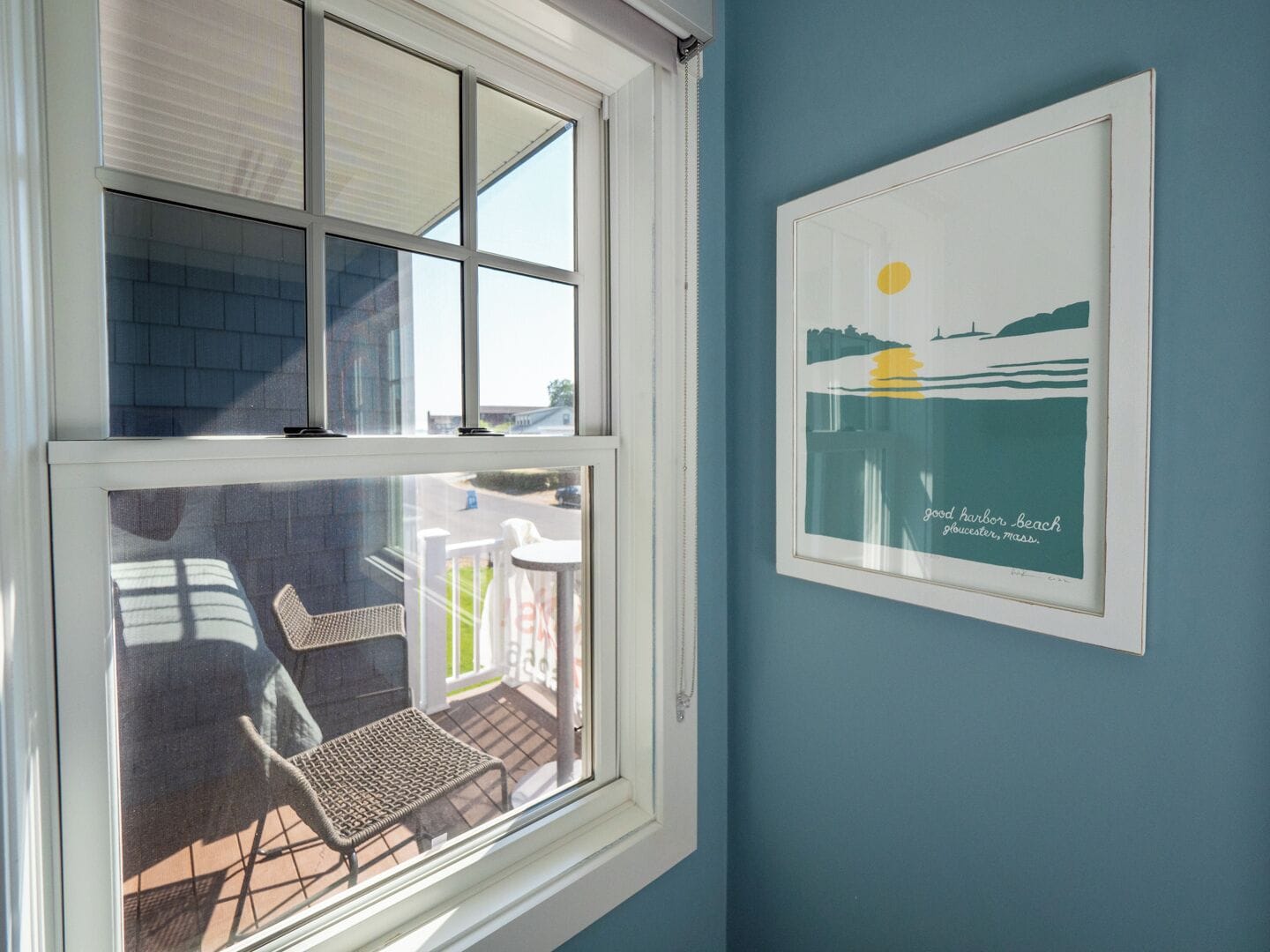 A room with a large window overlooking a patio with outdoor furniture.