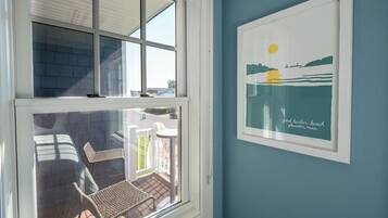 A room with a large window overlooking a patio with outdoor furniture.