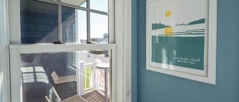 Une pièce dotée d’une grande fenêtre donnant sur un patio aménagé avec du mobilier d’extérieur.