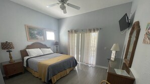 A bedroom with a bed, a chair, a desk, a television, and a ceiling fan. - -Near Disney-  condo in gated Bahama Bay Resort (Davenport)