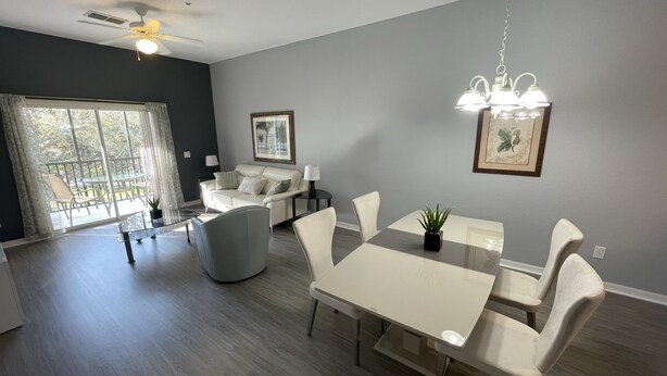 A modern living room with a dining area, a ceiling fan, and a view to the outside. - -Near Disney-  condo in gated Bahama Bay Resort (Davenport)