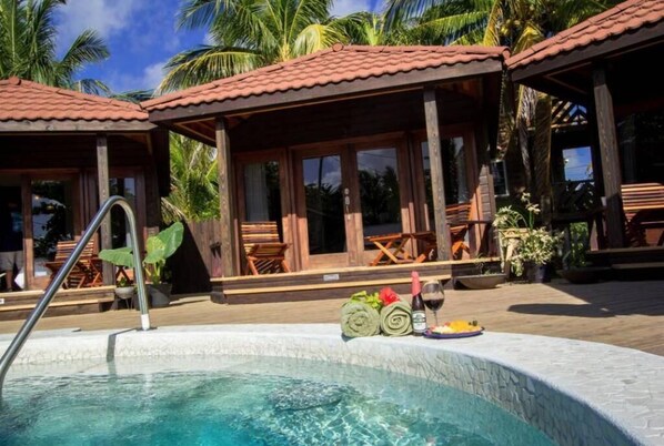A pool area with a tiled deck, wooden lounge chairs, and a small table with towels and a bottle of wine. - Marbucks Bed and Breakfast (San Pedro)