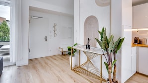 Une cuisine moderne avec un plan de travail blanc, une chaise de couleur dorée et un grand miroir.