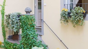 A narrow balcony with a door, potted plants, and a window with curtains. - Corte Paolina - charming courtyard inside Lucca (Lucca)