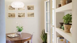 A dining area with a wooden table, a chandelier, and framed pictures on the wall. - Corte Paolina - charming courtyard inside Lucca (Lucca)