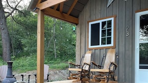 A wooden cabin with a porch, two Adirondack chairs, a large window, and a star decoration on the wall. - STARWOOD - PET FRIENDLY! - OFF GRID - ROMANTIC - ON WINE TRAIL (Hammondsport)