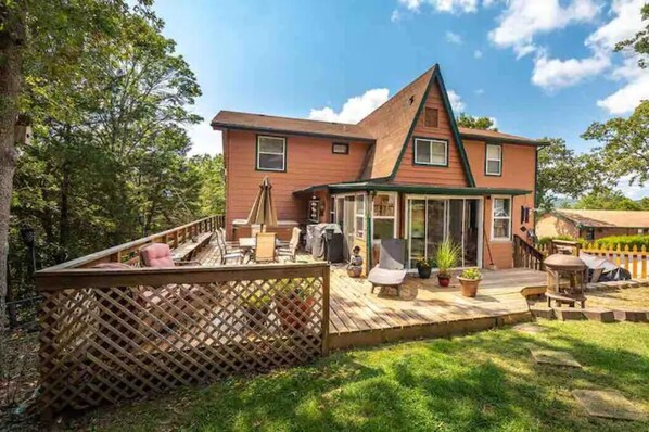 A two-story house with a deck, outdoor furniture, and a wooden fence. - The Bavarian Resort (Branson)