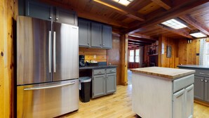 A modern kitchen with stainless steel appliances, wooden cabinets, and a herringbone floor pattern. - Spacious and Lovely Mountain Retreat (Bayfield)