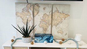 Un bureau orné d’une carte du monde, d’une plante, d’une boîte bleue et de divers objets décoratifs.