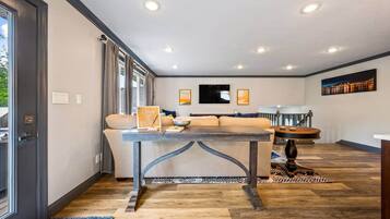 Un salon moderne avec un canapé, une table à manger et un coin cuisine à l’arrière-plan.