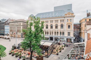 Un bâtiment historique doté d’une cour intérieure, d’un espace extérieur aménagé pour s’asseoir et d’une structure moderne en verre.
