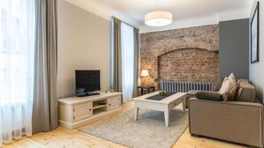 Ein modernes Wohnzimmer mit Backsteinwand, Flachbildfernseher, Sofa und Couchtisch.