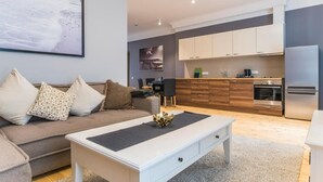Ein modernes Wohnzimmer mit einer Couch, einem Couchtisch und Kunstwerken an der Wand.