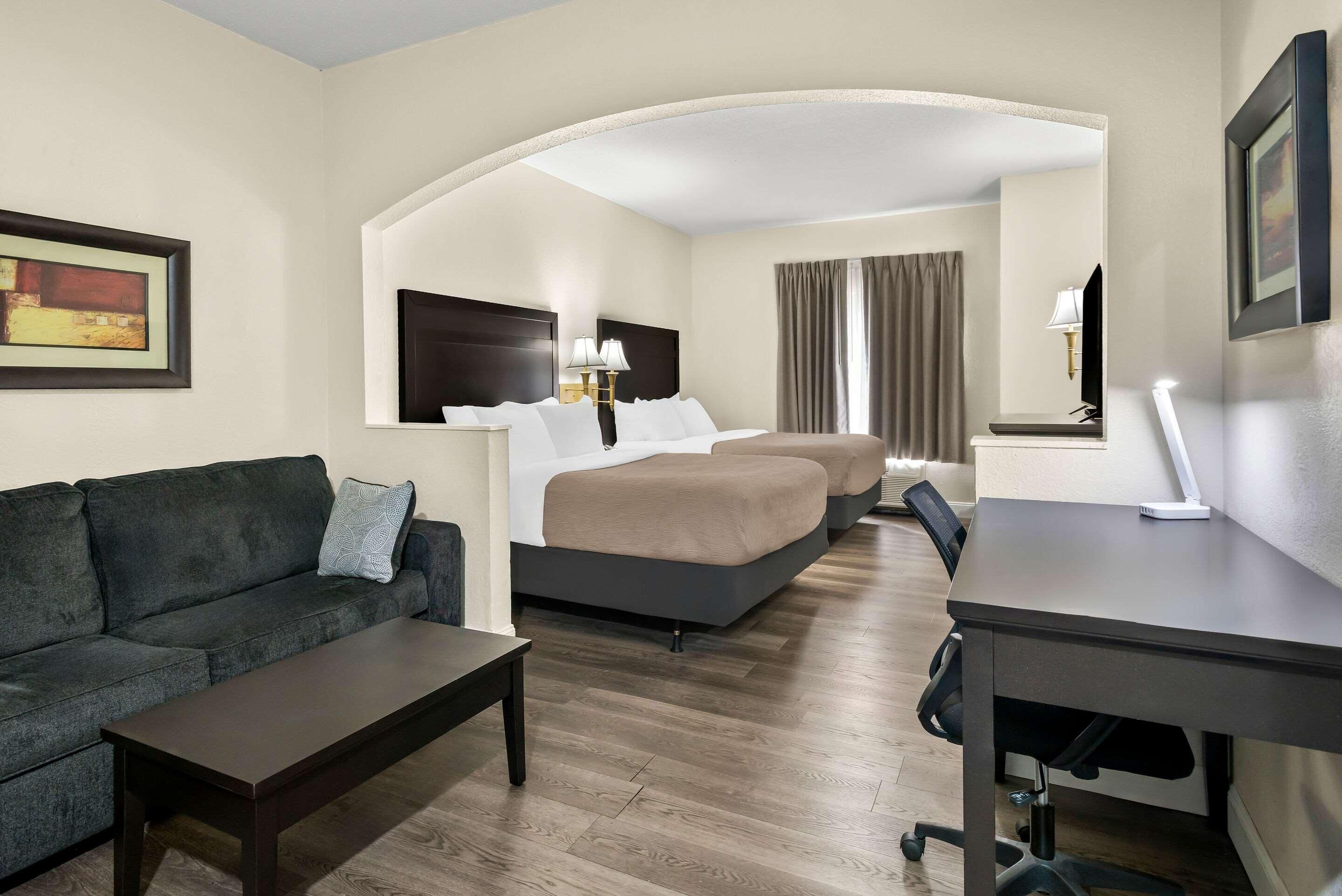 Habitación de hotel con sofá, cama, escritorio y silla.
